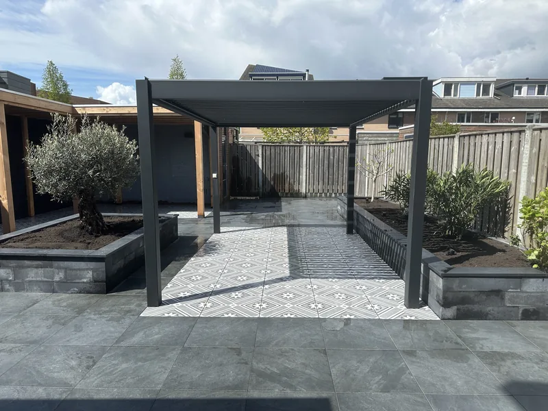 Strakke tuin met aluminium pergola en natuursteen terras in Bergschenhoek